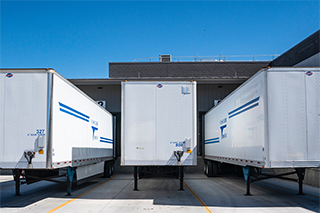 Semi-truck trailers parked at a warehouse for loading and unloading.
