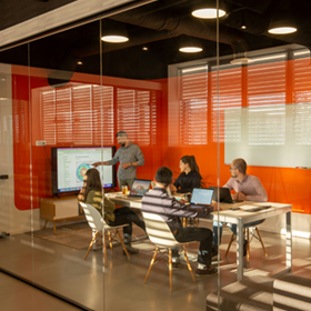 Coworkers meeting in a conference room to review a chart.