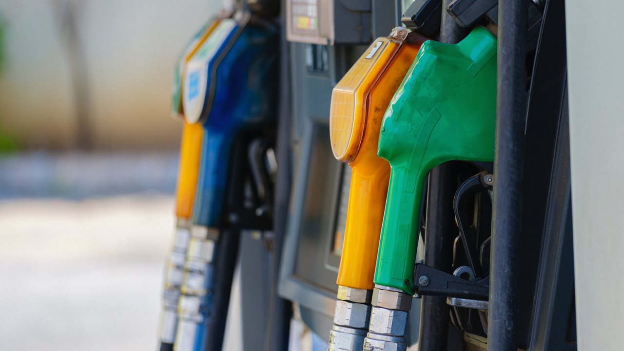 Closeup of gas pump with four different colored handles.