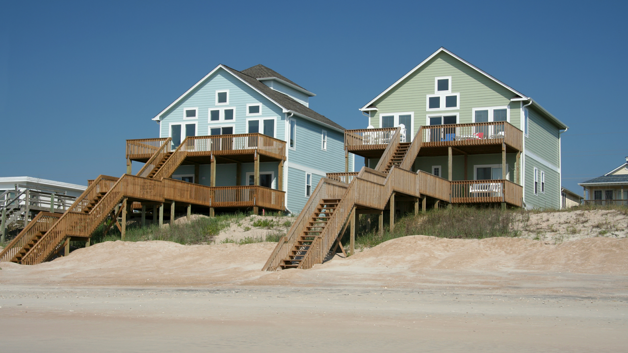 Two colorful ocean front beach houses on a bright, sunny day.