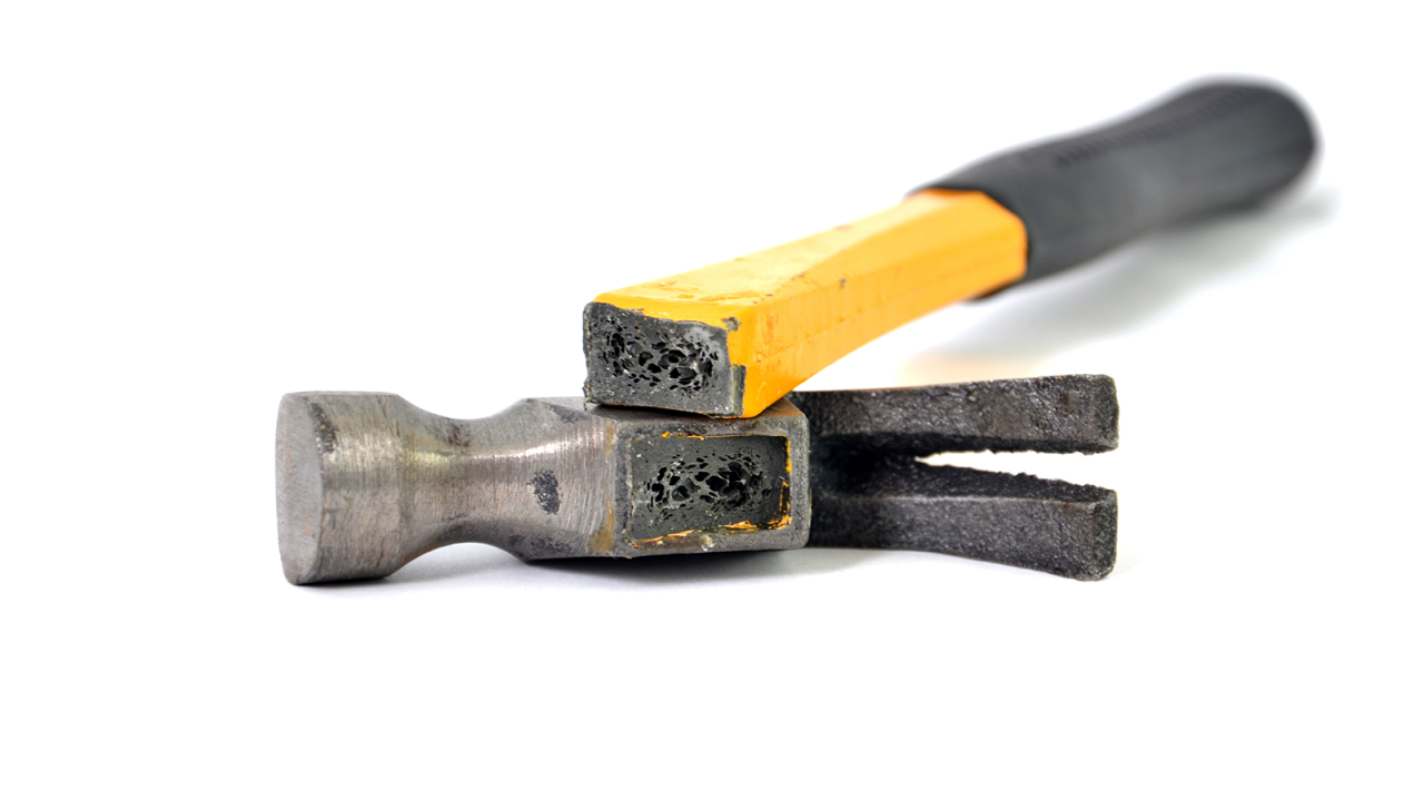 A broken hammer with yellow handle and black grip